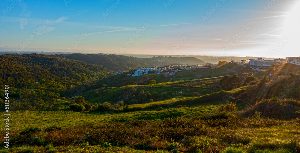 beautiful small European city with a beautiful hilly landscape while sunset. Top view of a European village with beautiful green landscape with a morning fog.