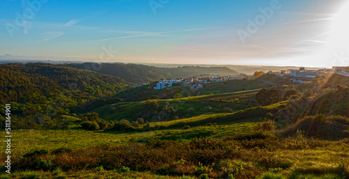 beautiful small European city with a beautiful hilly landscape while sunset. Top view of a European village with beautiful green landscape with a morning fog.