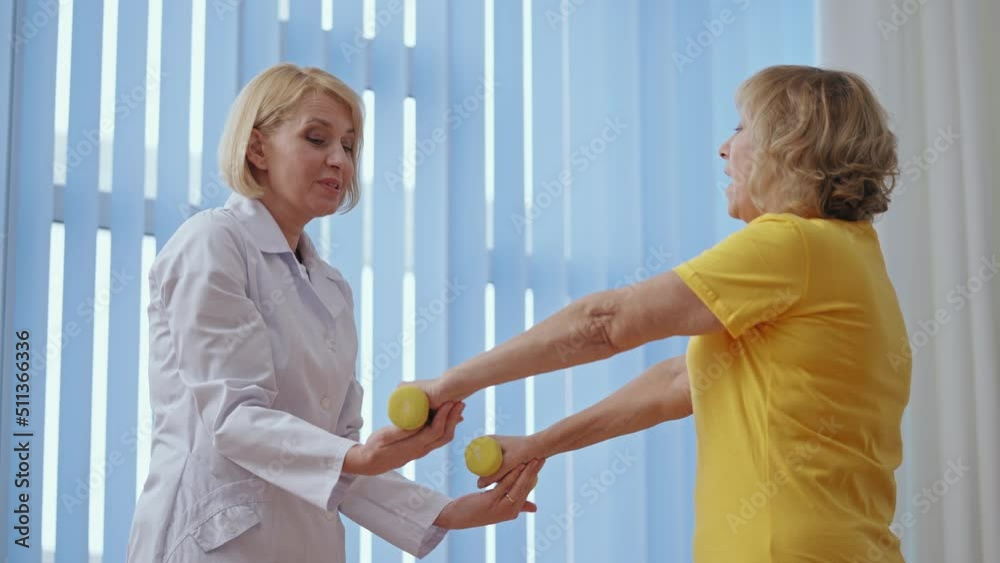 Patient feeling pain while doing exercises under doctor's supervision in clinic Patient feeling pain while doing exercises under doctor's supervision in clinic
