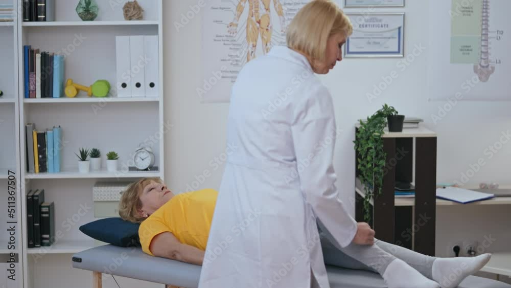 Certified orthopedist examining knee of her patient, making diagnosis, physiatry Certified orthopedist examining knee of her patient, making diagnosis, physiatry