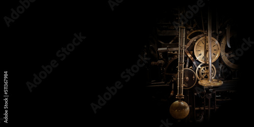 The mechanism of an old antique watch in the dark. Surrounded by black space. photo