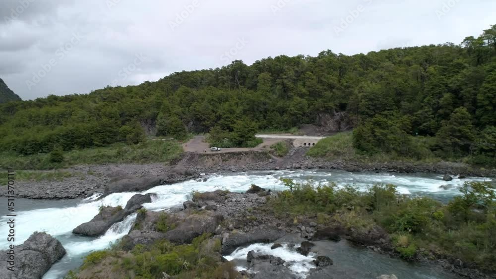 Aerial Backward Shot Of Tourists By Flowing Stream Under Cloudy Sky On Vacation - Puerto Montt, Argentina Aerial Backward Shot Of Tourists By Flowing Stream Under Cloudy Sky On Vacation - Puerto Montt, Argentina