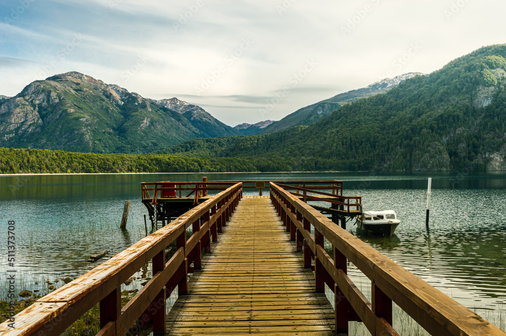 Wooden pier on a beautiful lake and the Andes mountain range in the background. Alerces National Park. Chubut, Argentina