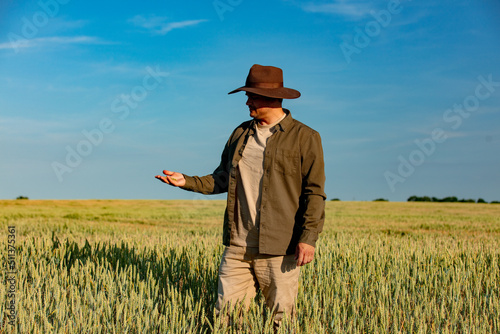 farmer checks the quality of wheat in the field © Simonforstock