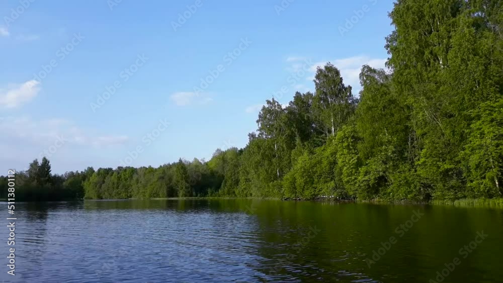 Summer landscape. River or lake, surrounded by green trees. Sunny weather. Ripples on water. Summer landscape. River or lake, surrounded by green trees. Sunny weather. Ripples on water.