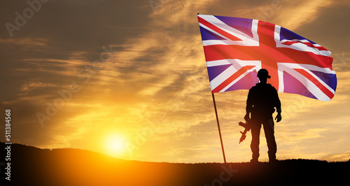Foto Silhouette of soldier with United Kingdom flag on background of sunset