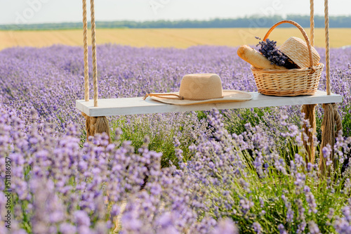 lavender field, hat and picnic basket on a swing swing, a symbol of summer va...