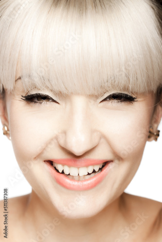 Close up portrait of a beautiful brunette girl with blond bangs fringe. Positive happy smiling face expression..
