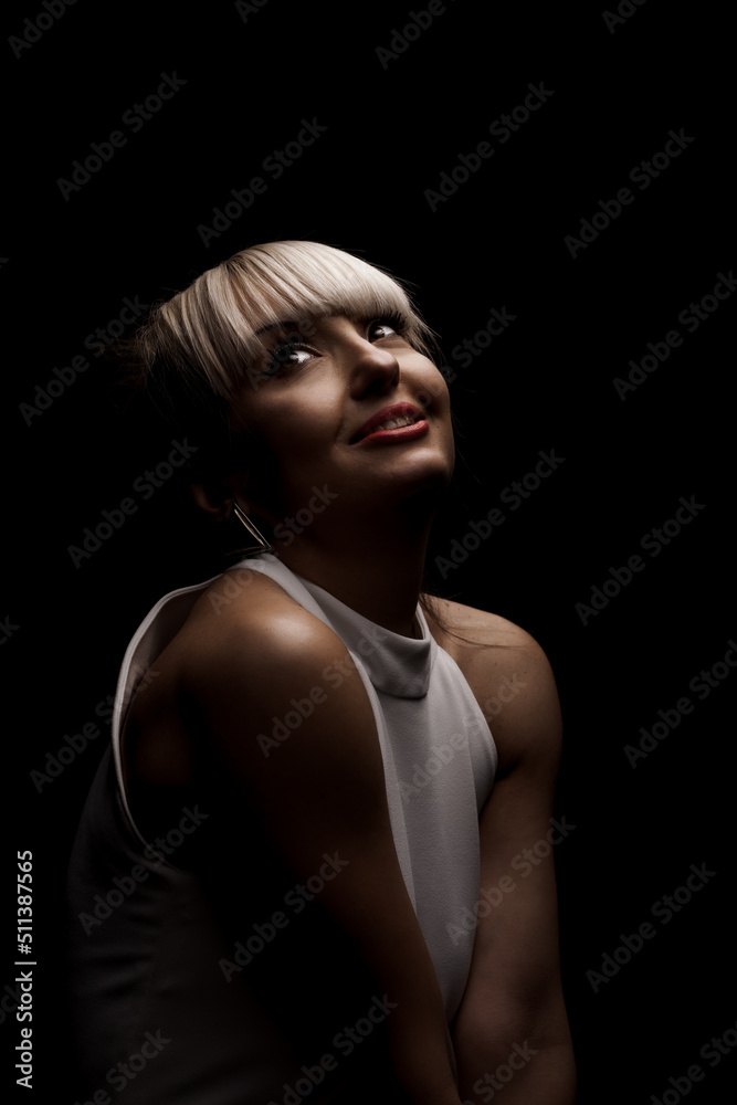 Beautiful girl with blond bangs fringe wearing white fashionable fancy dress against black background. . Beautiful girl with blond bangs fringe wearing white fashionable fancy dress against black background. .