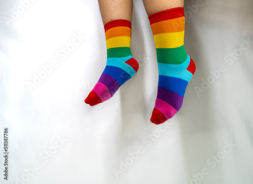 Legs in colorful rainbow socks against white background