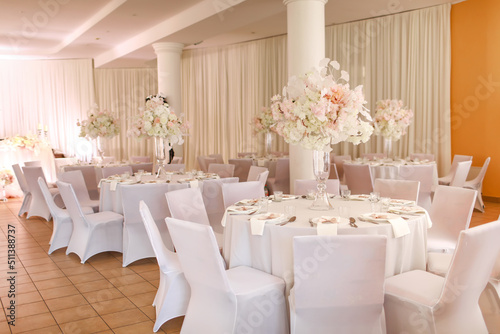 festive wedding decoration. Beautiful fresh white and pink flowers in glass vase on dining table on wedding day. High quality photo