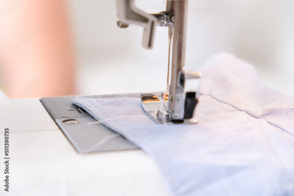 A man sews clothes on a sewing machine. Hobbies, needlework, creativity.
