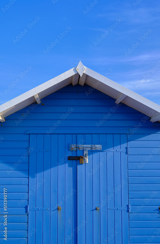 The front of a brightly coloured blue beach hut in Eastbourne on a sunny summer's day The front of a brightly coloured blue beach hut in Eastbourne on a sunny summer's day
