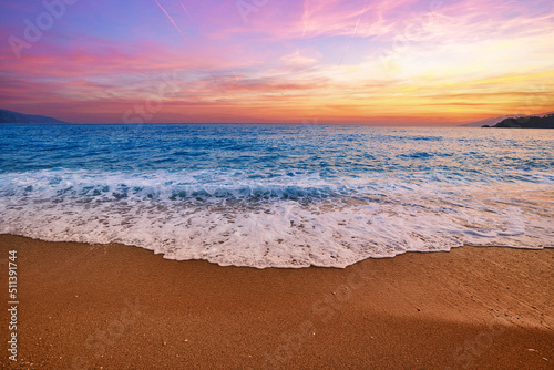 Landscape of gorgeous beautiful romantic idyllic blue turquoise sea with foam, gradient sky and sandy beach