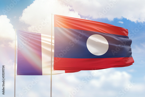 Sunny blue sky and flags of laos and france