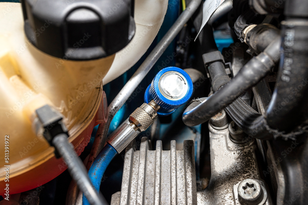 A blue quick-release coupler is installed on the valve from the air conditioning system in the car to fill the R134a refrigerant. A blue quick-release coupler is installed on the valve from the air conditioning system in the car to fill the R134a refrigerant.