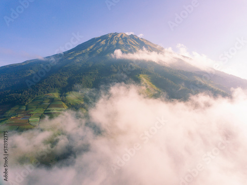 The peak of the Mount Sumbing with sea of clouds and blue sky. Central Java, Indonesia