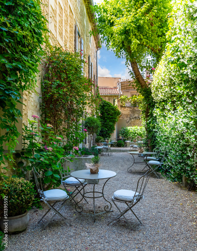 Fototapeta An empty, secluded cafe patio garden in the medieval village of Saint-Remy-de-Provence, in the Provence Cote d'Azur region of Southern France.