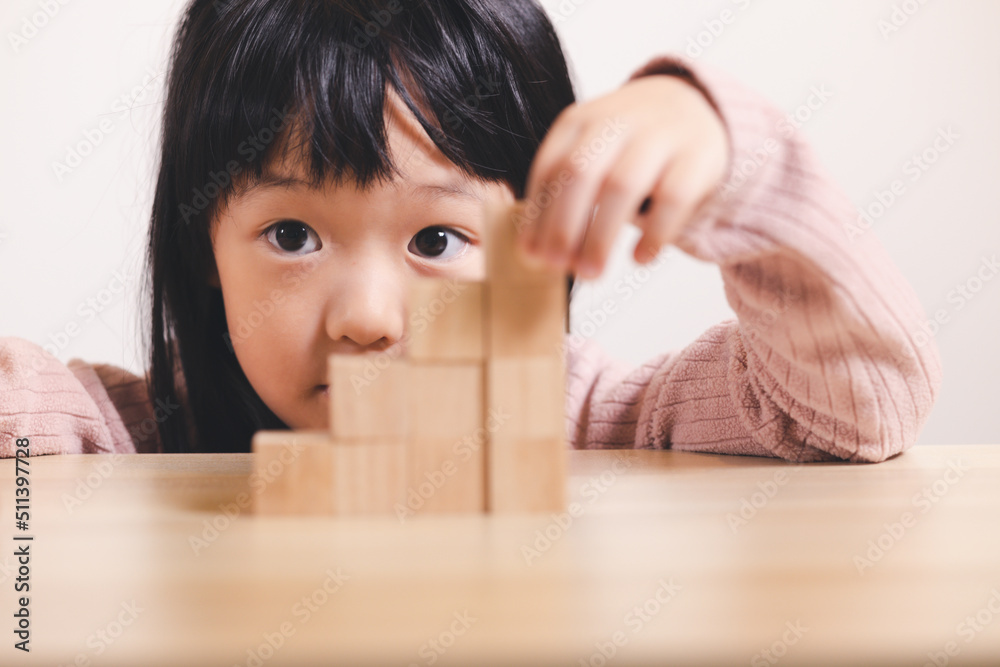 Asian kid stack small wooden block to stair. Concept for kid learning and child development. Asian kid stack small wooden block to stair. Concept for kid learning and child development.