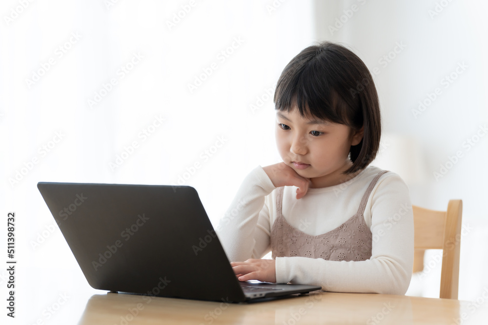 パソコンを使いながら困った顔をする女の子 パソコンを使いながら困った顔をする女の子