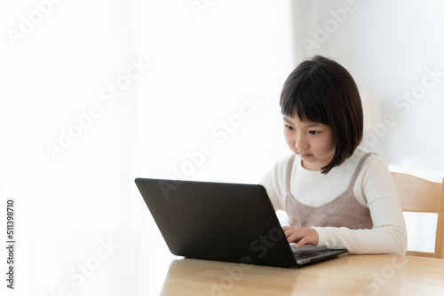 リビングでパソコンを使う女の子 © taka