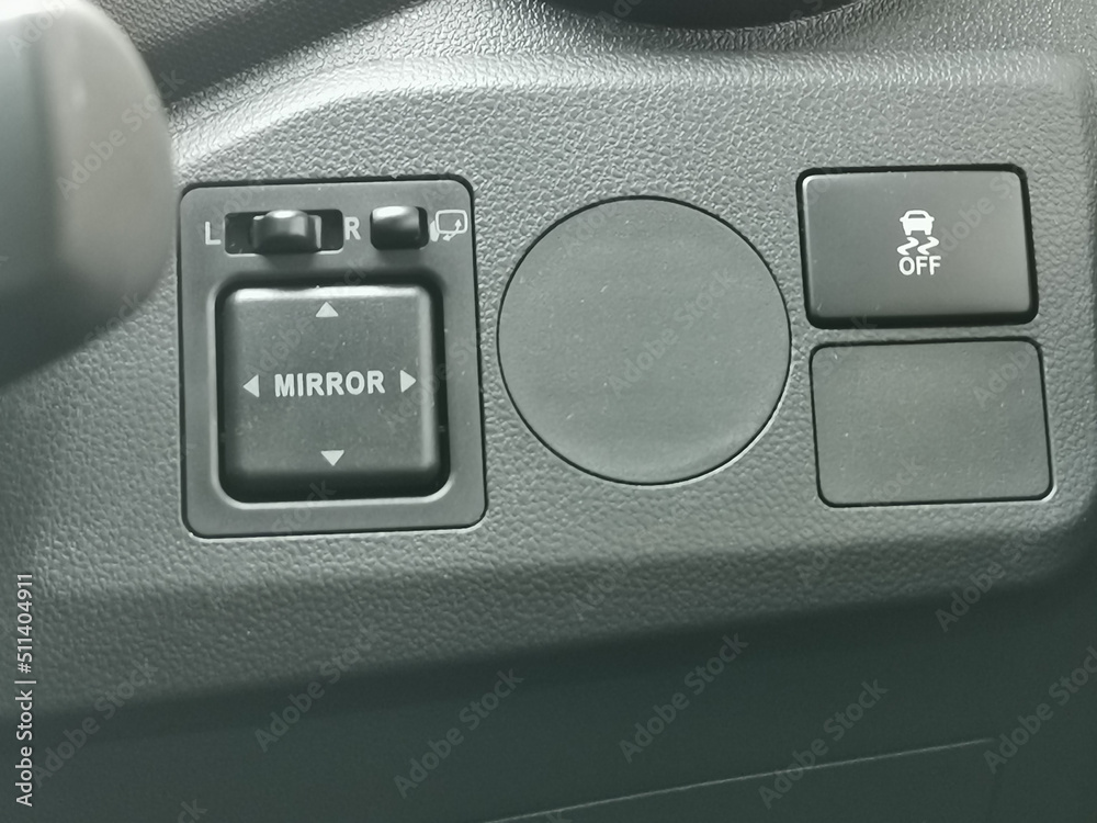 Photo of car side mirror button adjustment on the dashboard. Photo of car side mirror button adjustment on the dashboard.