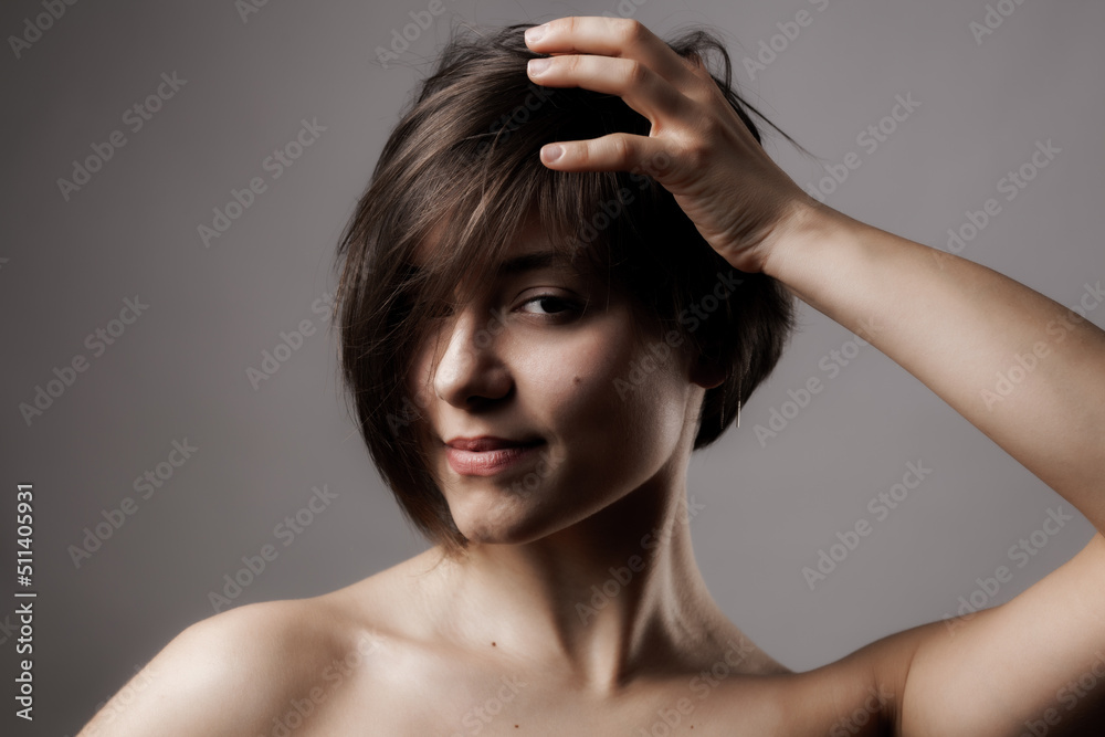 Naklejka premium Close up portrait of a beautiful girl. Short hairstyle against gray background.