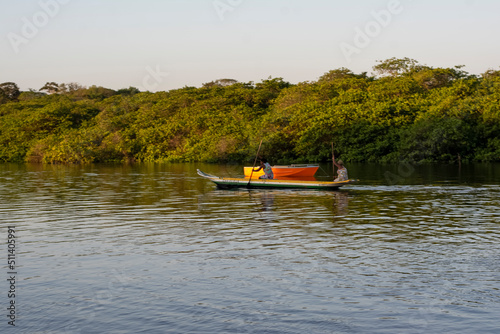 Fisherwoman rowing the canoe towards the Jaguaripe river pier photo