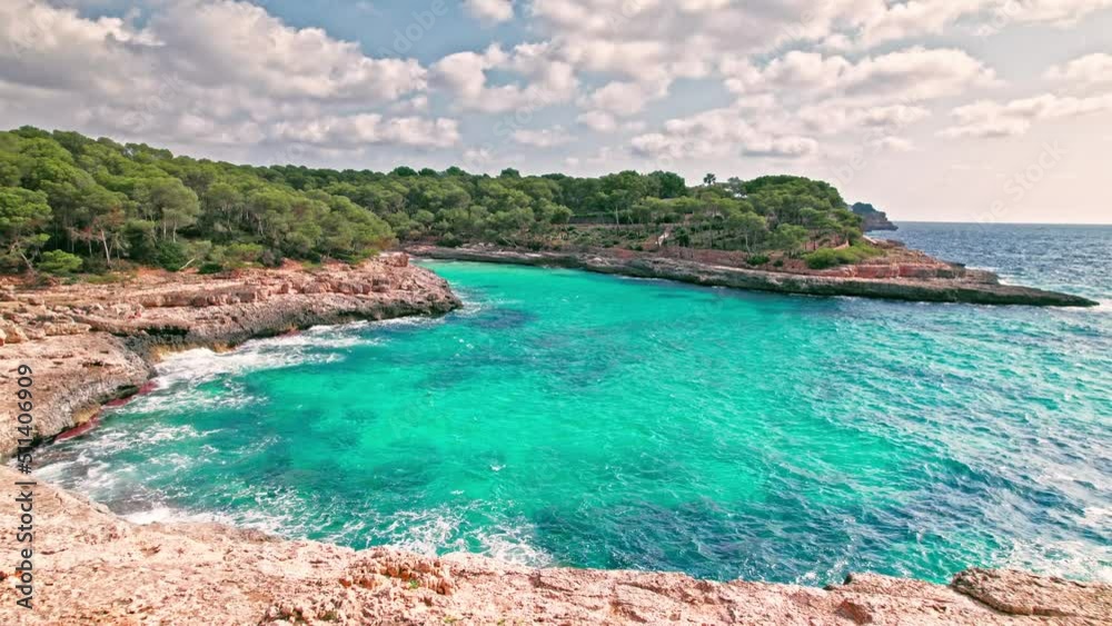 Mediterranean rocky beach with caves in Majorca, Spain with transparent water. Crystal clear sea with turquoise waters by Caló des Borgit beach on Mallorca, Balearic Islands.