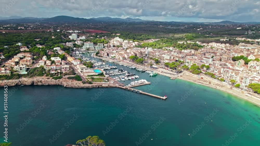 Scenic Porto Cristo Marina view from above with houses by the coast in Majorca. A view of a Spanish village known for amazing Drach Caves on the Balearic Islands, Spain.