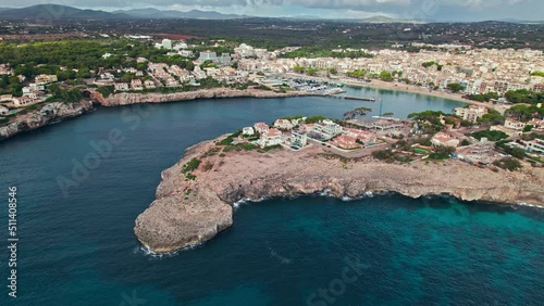 Scenic Porto Cristo Marina view from above with houses by the coast in Majorca. A view of a Spanish village known for amazing Drach Caves on the Balearic Islands, Spain. photo