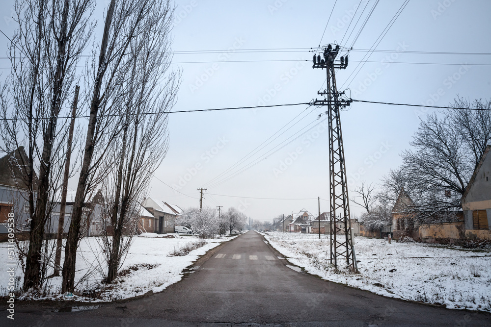 Selective blur on an empty road and street in the village of Bavaniste, in Vojvodina, Banat, Serbia, in the countryside, covered in snow, during a cold freezing afternoon of winter. ..... Selective blur on an empty road and street in the village of Bavaniste, in Vojvodina, Banat, Serbia, in the countryside, covered in snow, during a cold freezing afternoon of winter. .....