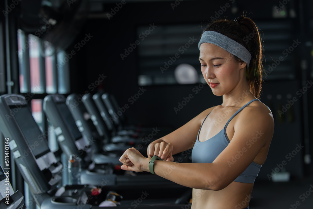 woman working out in a gym. woman lookinng time and heart on Smart watch. woman working out in a gym. woman lookinng time and heart on Smart watch.