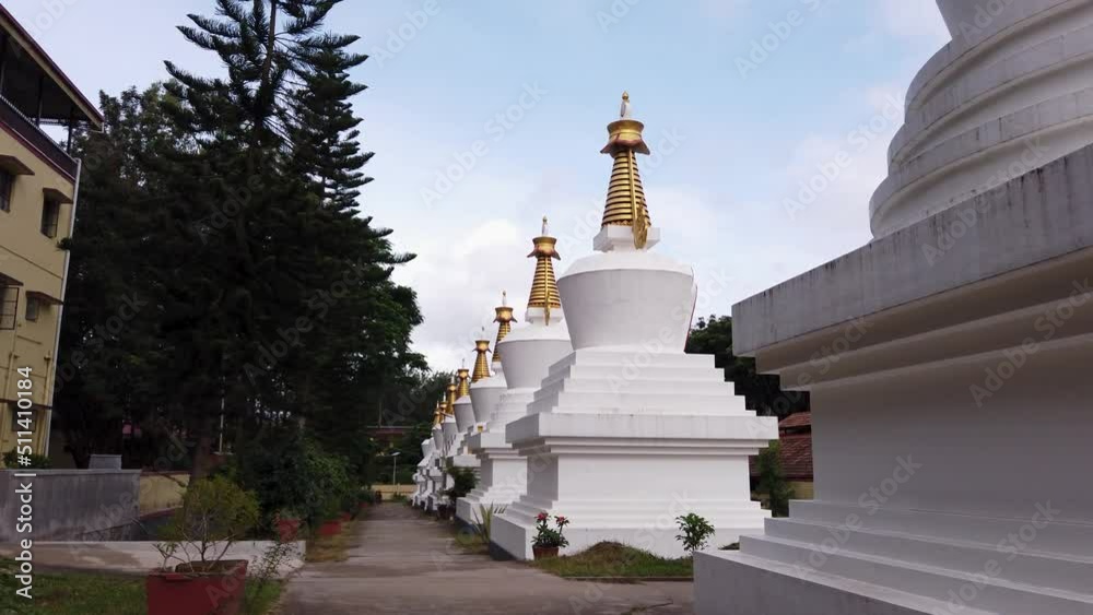  A Group of Large Stupas in White color housing earthly remains of Buddha and his followers at the Golden temple of Tibetan settlement in Bylakuppe, India.
