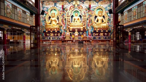  A Dramatic scene of the Tibetan Monastery interiors where large statues of Buddhas in different forms decorated with Gold at Bylakuppe town in India which is an famous travel destination. photo