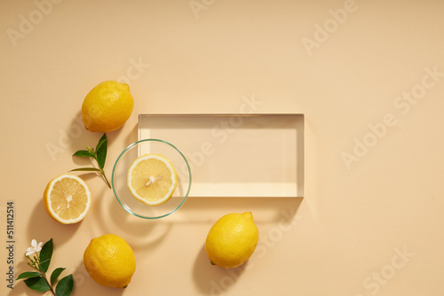 Top view of lemon decorated with transparent podium and green leaf blank space for advertising 