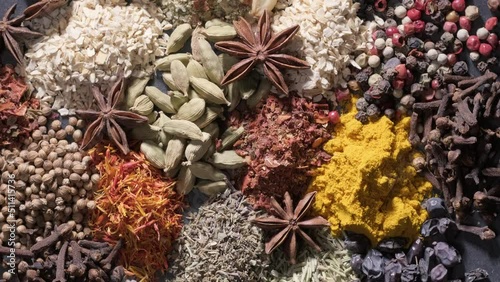 4K. Spices. Aromatic Indian spices on a slate background. Spices and herbs rotate on a stone background. Assortment of Seasonings, condiments, Dry colorful condiments. Culinary, cooking ingredients