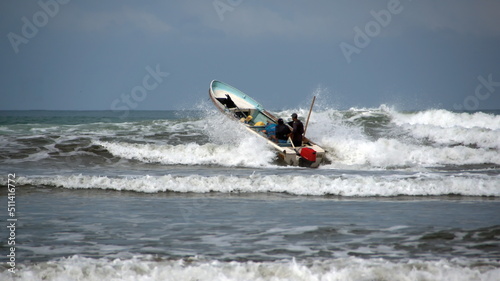 Fishing boat being launched through the surf, from the beach, in Canoa, Ecuador