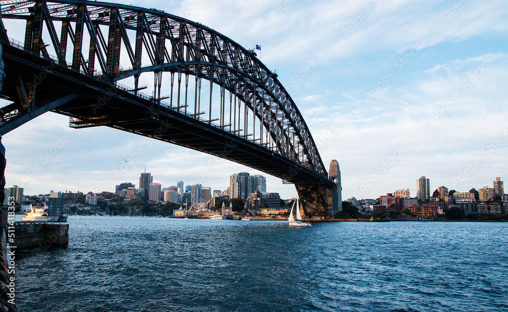 small yacht sailing under Sydney Harbour Bridge small yacht sailing under Sydney Harbour Bridge