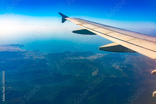 View from the airplane window at a beautiful blue clear sky and the airplane wing