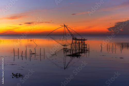 The scenery of sunrise and sunset view with giant fishing traps in Southern of Thailand.