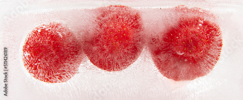 Strawberry frozen inside ice on white background.
