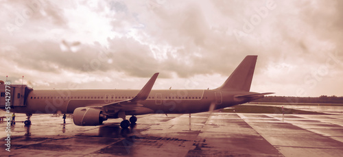 A passenger plane is preparing to take passengers on board. Panoramic side view.