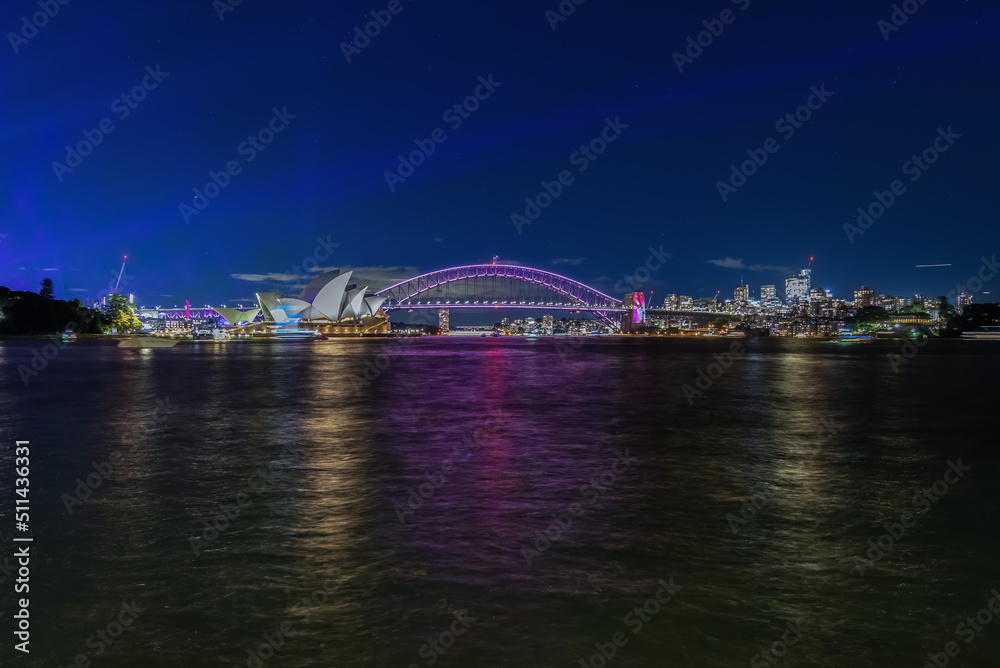 Colourful Light show at night on Sydney Harbour NSW Australia. The bridge illuminated with lasers and neon coloured lights. Sydney laser light show