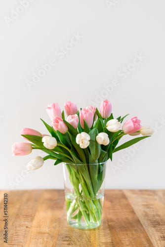Bouquet of delicate pink and white tulips in a vase.