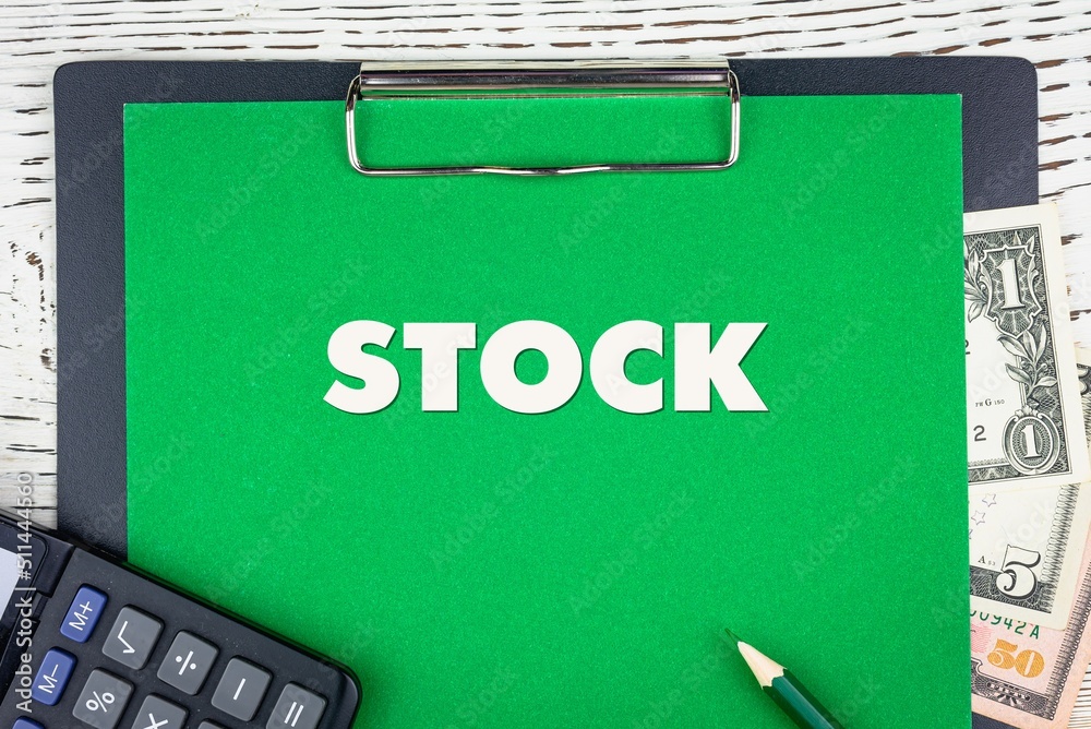 Obraz premium STOCK - word (text) dollar bills on green background, pencil, calculator and wooden white table. Business concept: buying, selling, commerce (copy space).