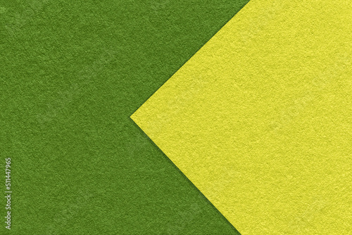 Texture of dark green and olive paper background, half two colors with arrow, macro. Structure of dense craft cardboard.