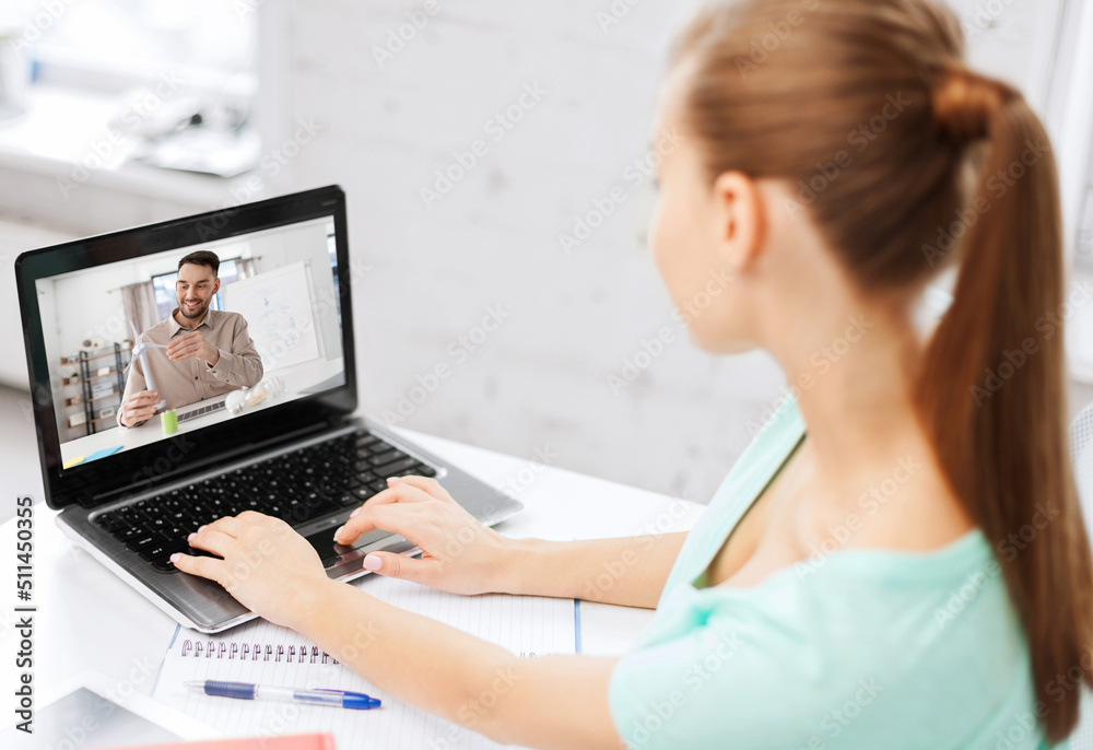 Fototapeta premium education, online school and distance learning concept - student woman with teacher showing wind turbine model on laptop computer screen having video call at home