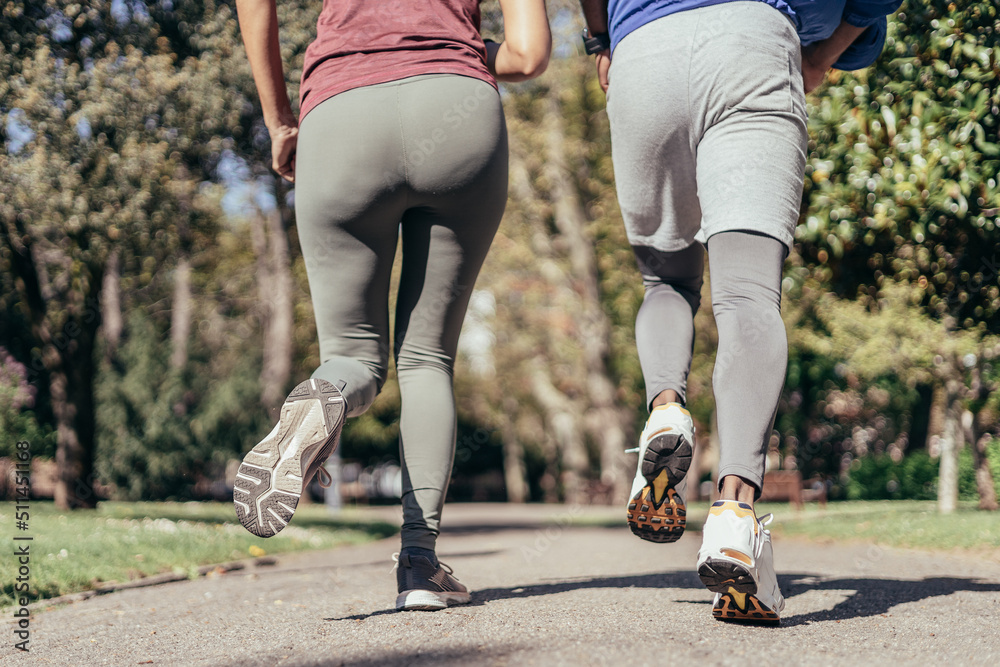 Fototapeta premium Rear close up view of two runner legs in park