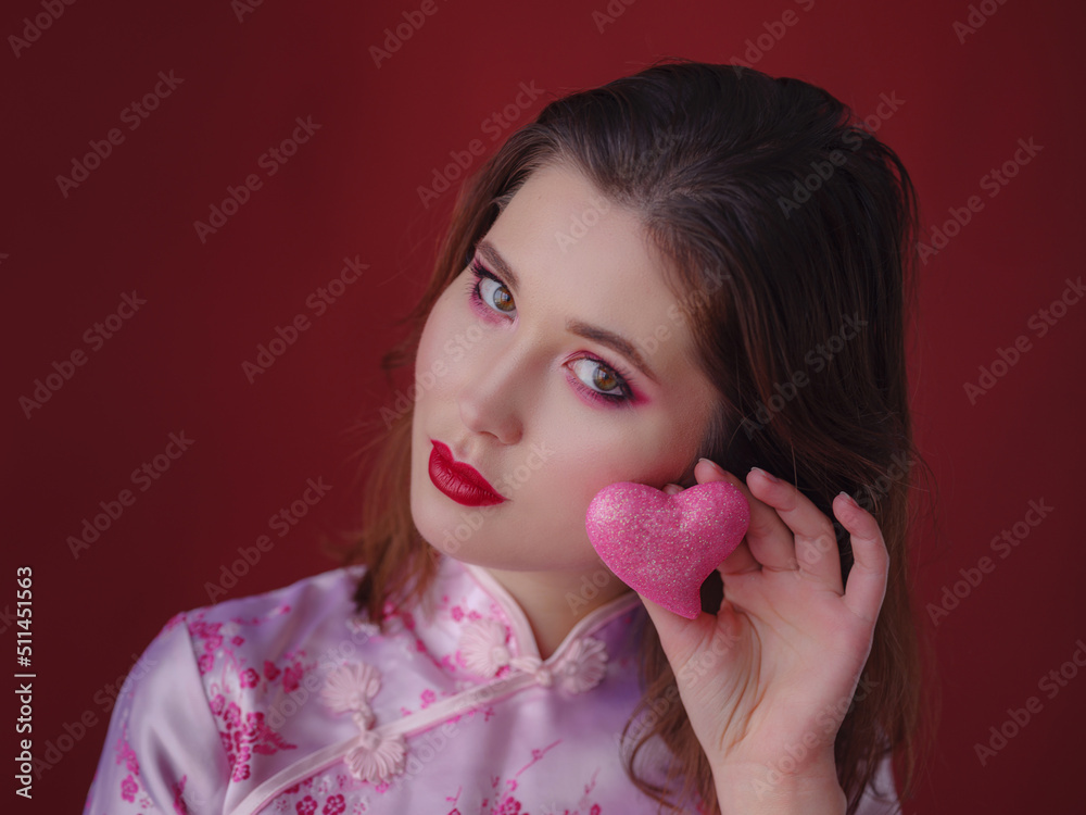 Portrait of charming asian lady hold holding small shiny heart Portrait of charming asian lady hold holding small shiny heart